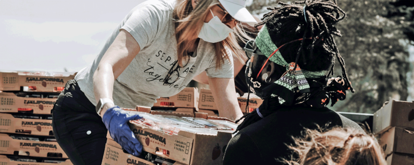 a person wearing a mask and gloves with a group of boxes